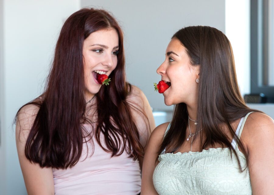 Kaksi tyttöä mansikat suussa